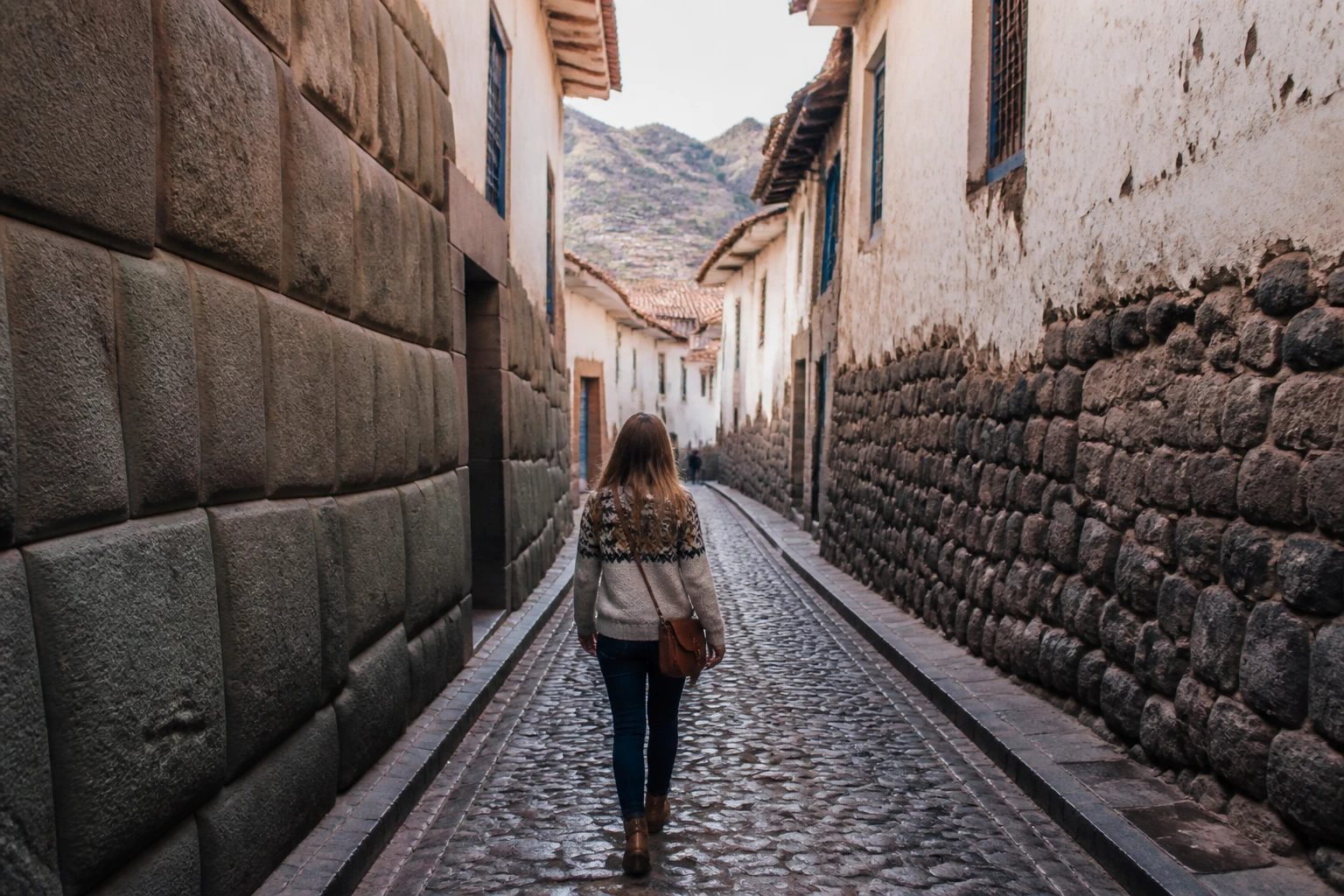 Traveler walking along a stone street in Cusco