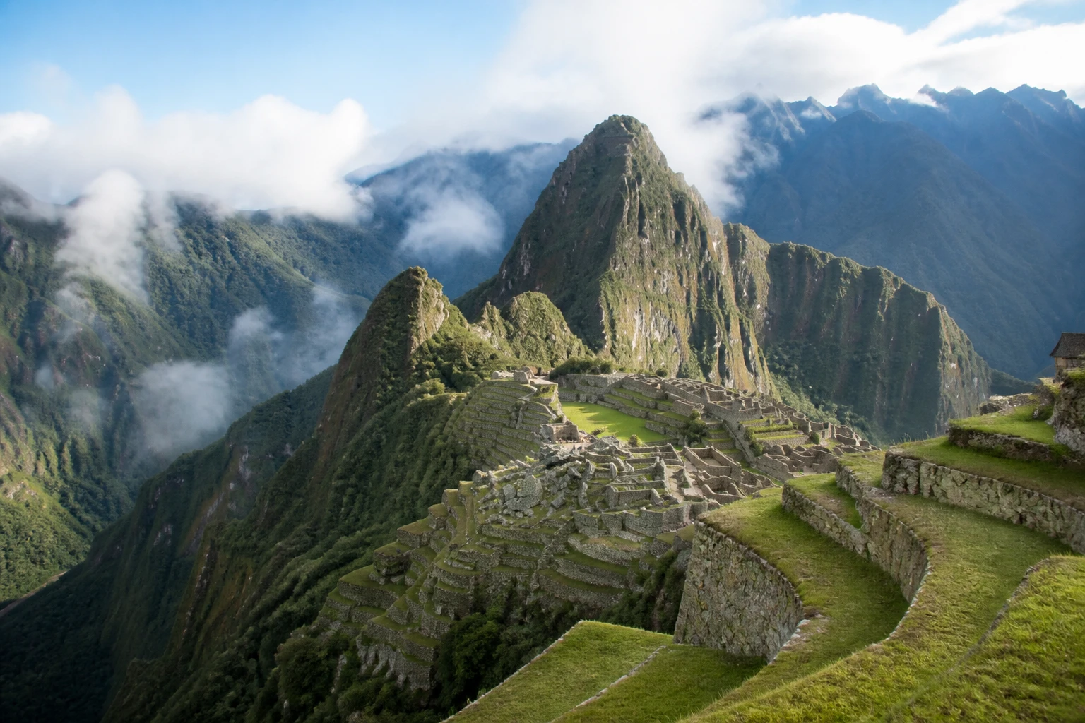 Machu Picchu terraces surrounded by steep green mountains