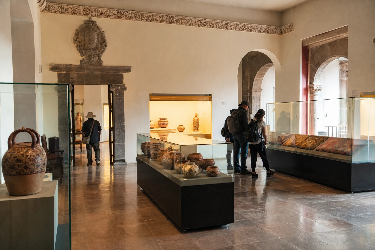 Visitors viewing pre-Columbian objects in a museum gallery in Cusco