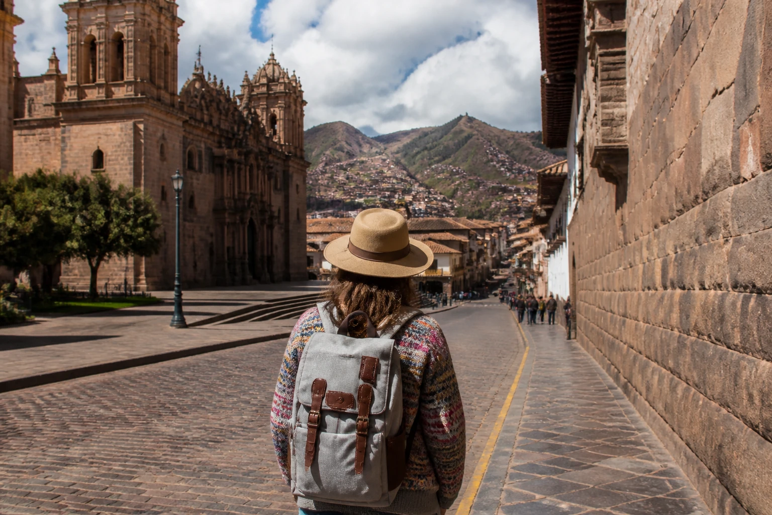 Traveler in layered clothing carrying a light daypack in Cusco