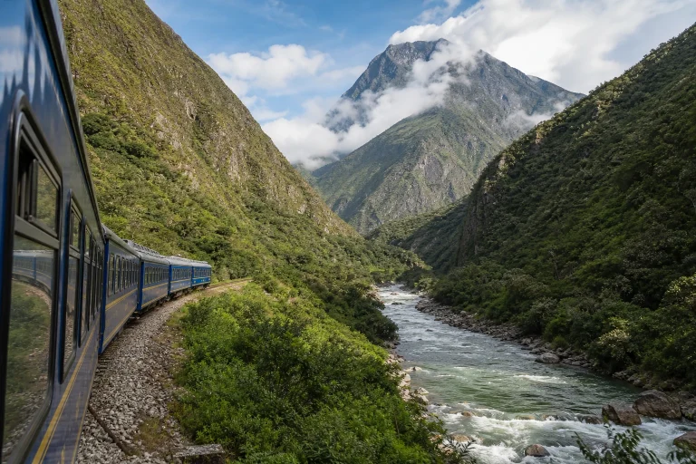 Passenger train traveling through an Andean valley on the route to Machu Picchu.