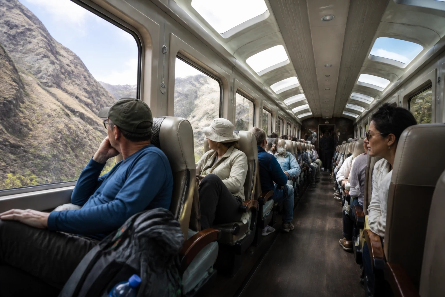 Travelers with small bags inside a train carriage on the Machu Picchu route.