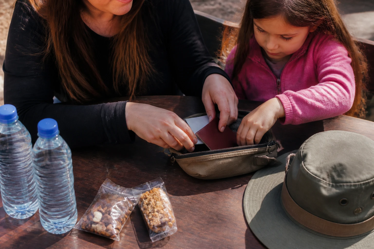 A parent organizing family travel documents and snacks