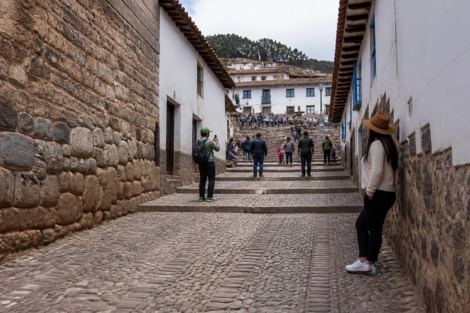 Travelers walking uphill on the cobbled route to San Blas